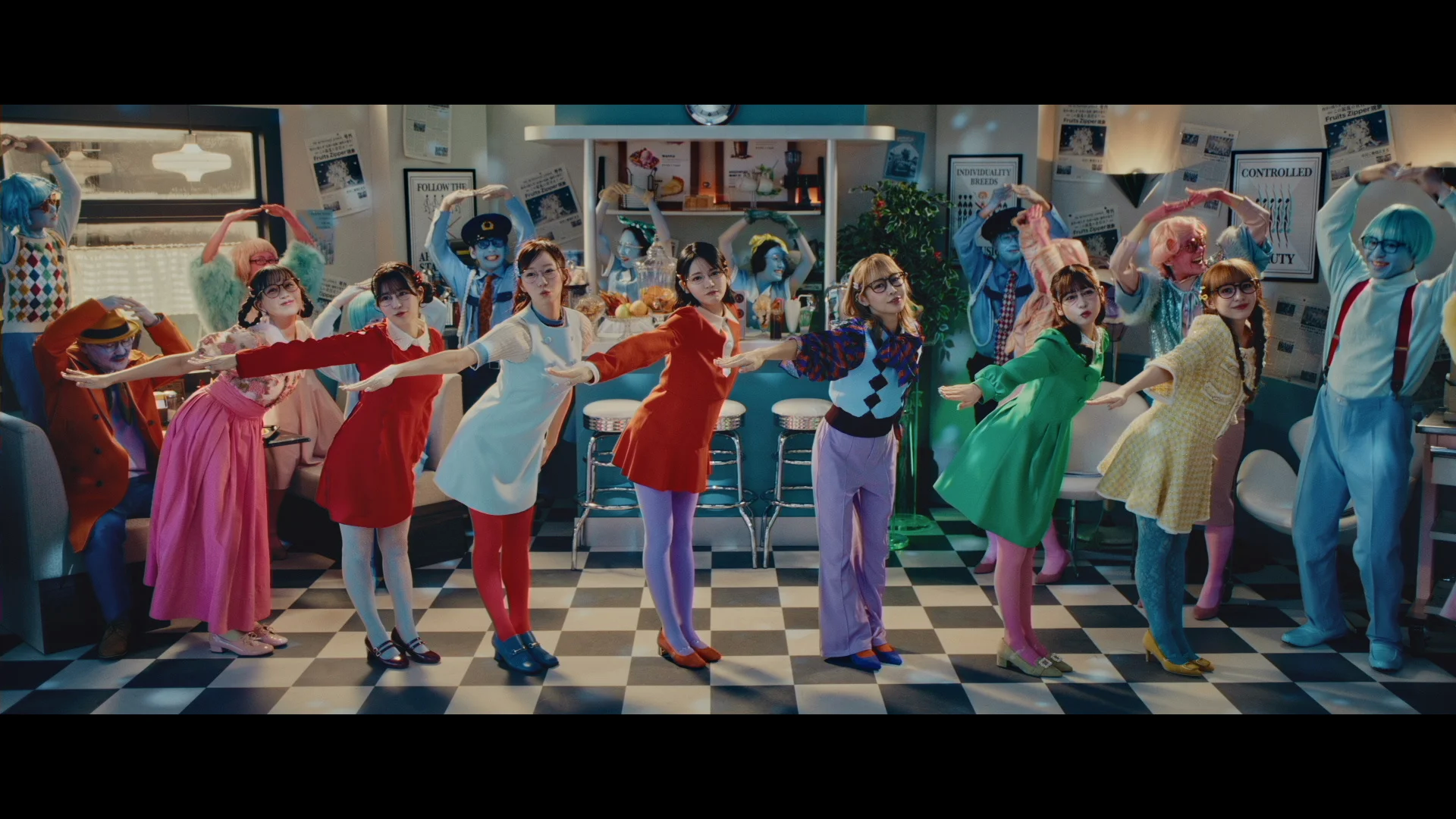 Kolorowa grupa wykonawców w eklektycznych strojach tańcząca w retro jadłodajni