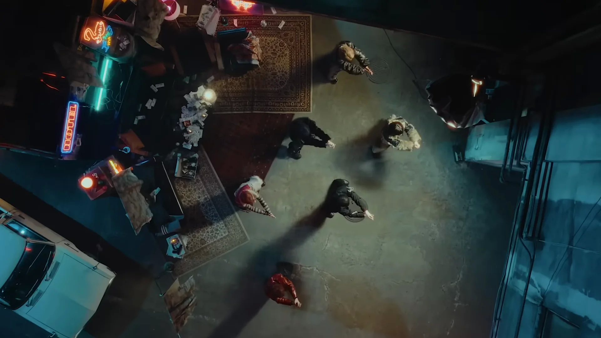 एक मंद रोशनी वाला सेट जिसमें कलाकार और बिखरी हुई वस्तुएं हैं