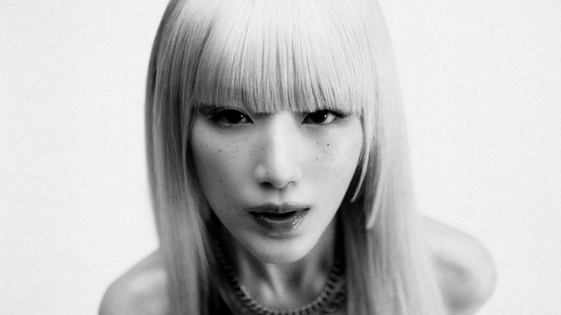 Aworan alawọ dúdú ati funfun ni sunmọ ẹni kan pẹlu irun t