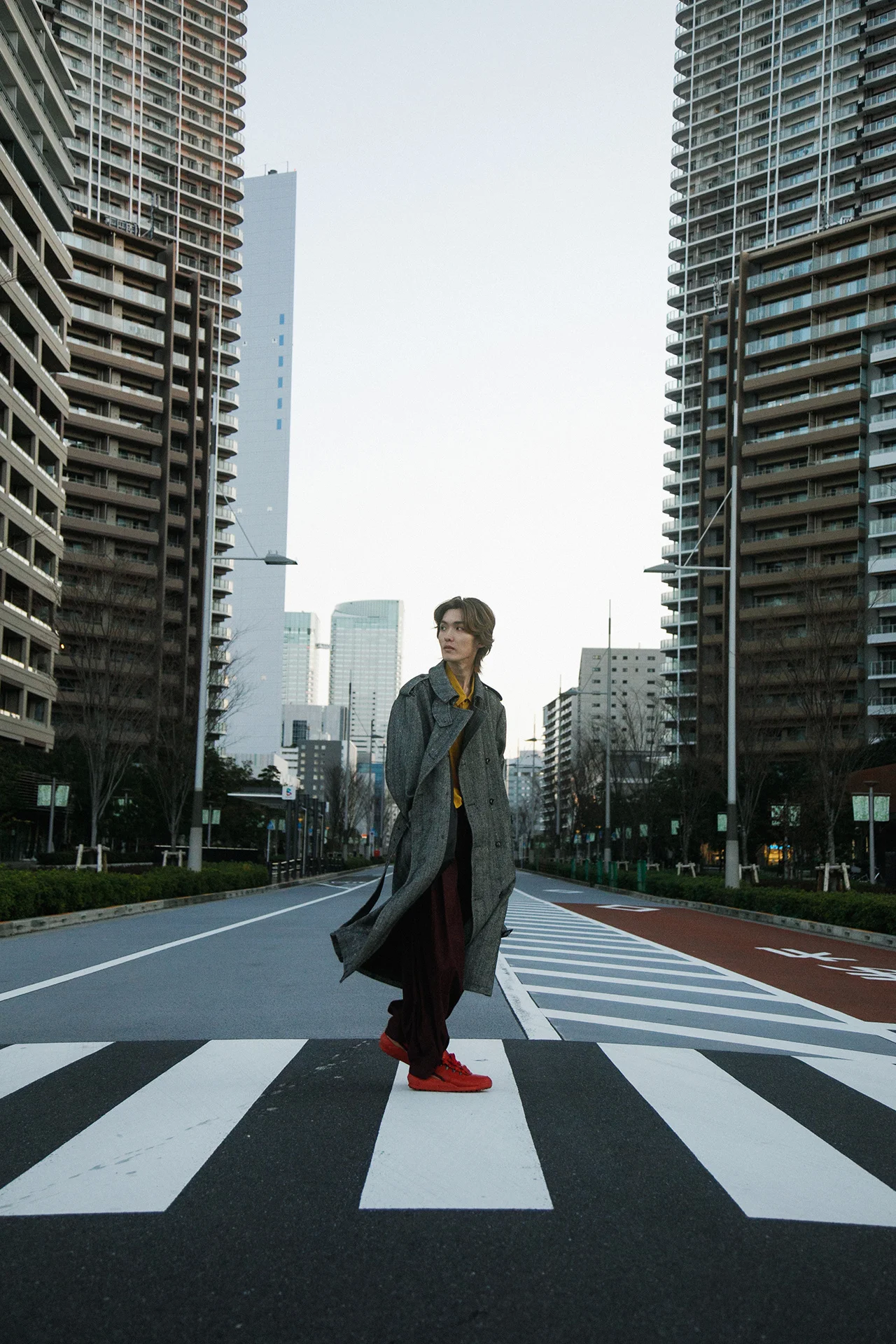 Guiano stând pe o trecere de pietoni într-un decor urban