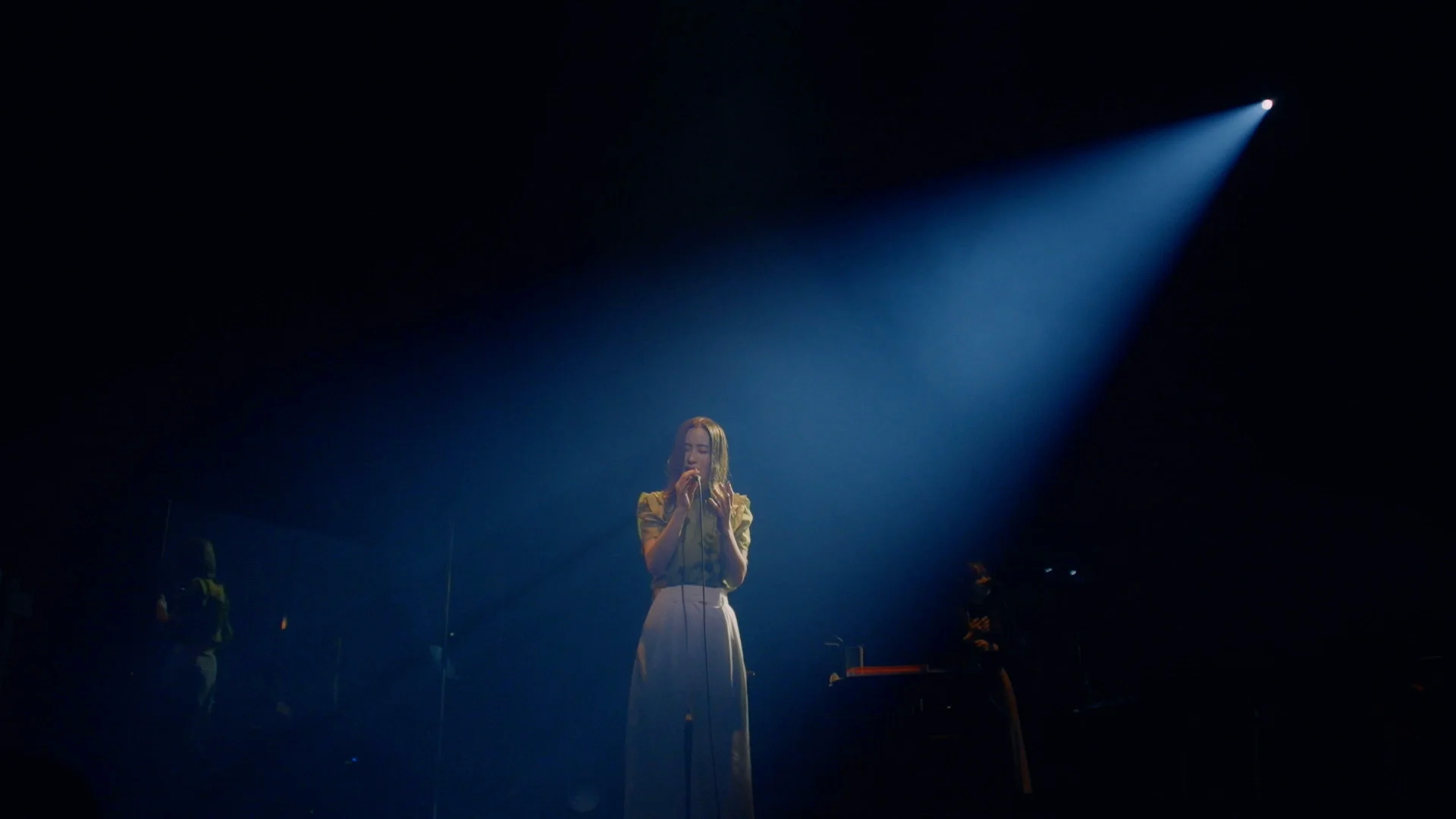 Uru se apresentando no palco sob um holofote