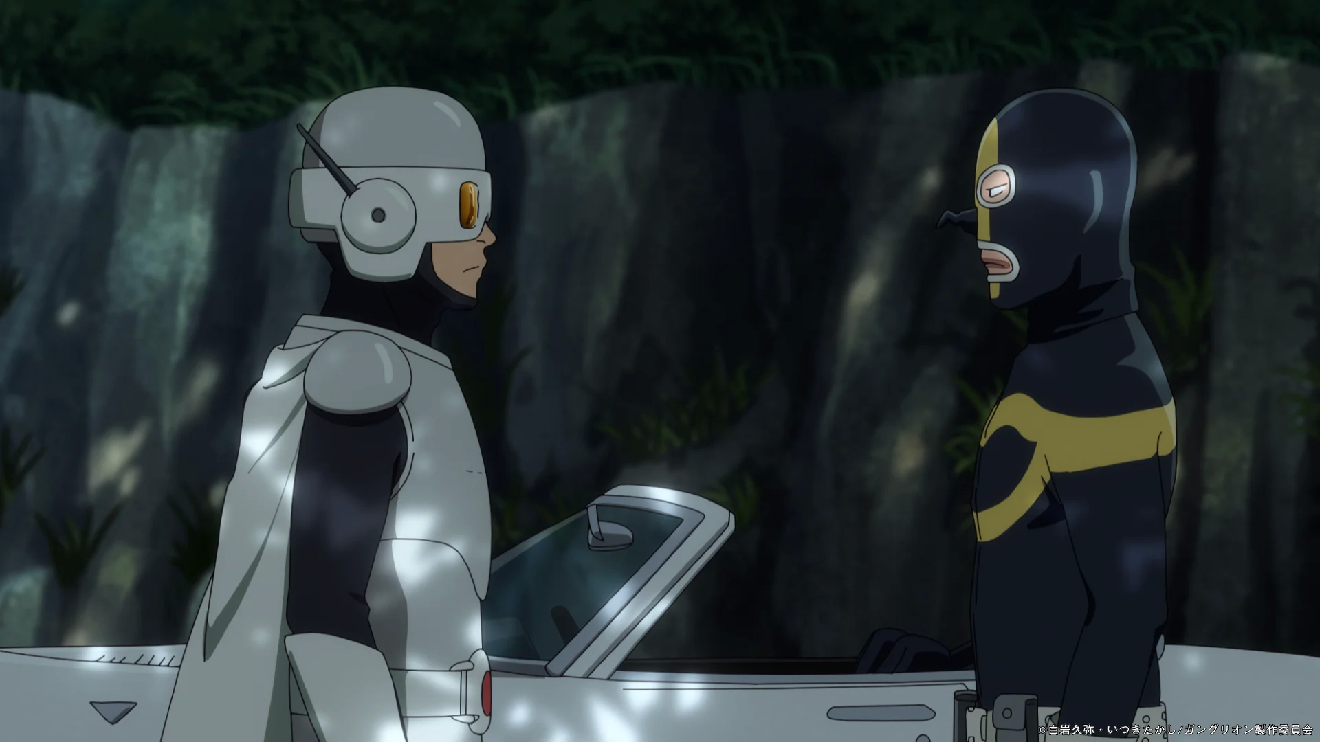 Эки каарман өзгөчө костюмдарда түн ичинде ак унаанын сыртында сүйлөшүп турушат.