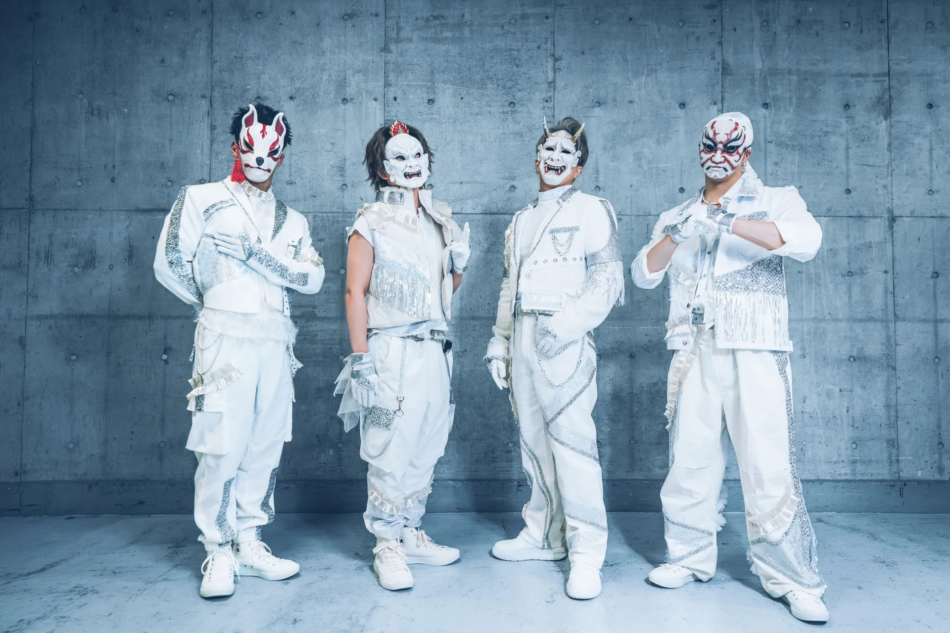 Kat manm O-MENZ nan rad blan ak mask poze kont yon mi konkè