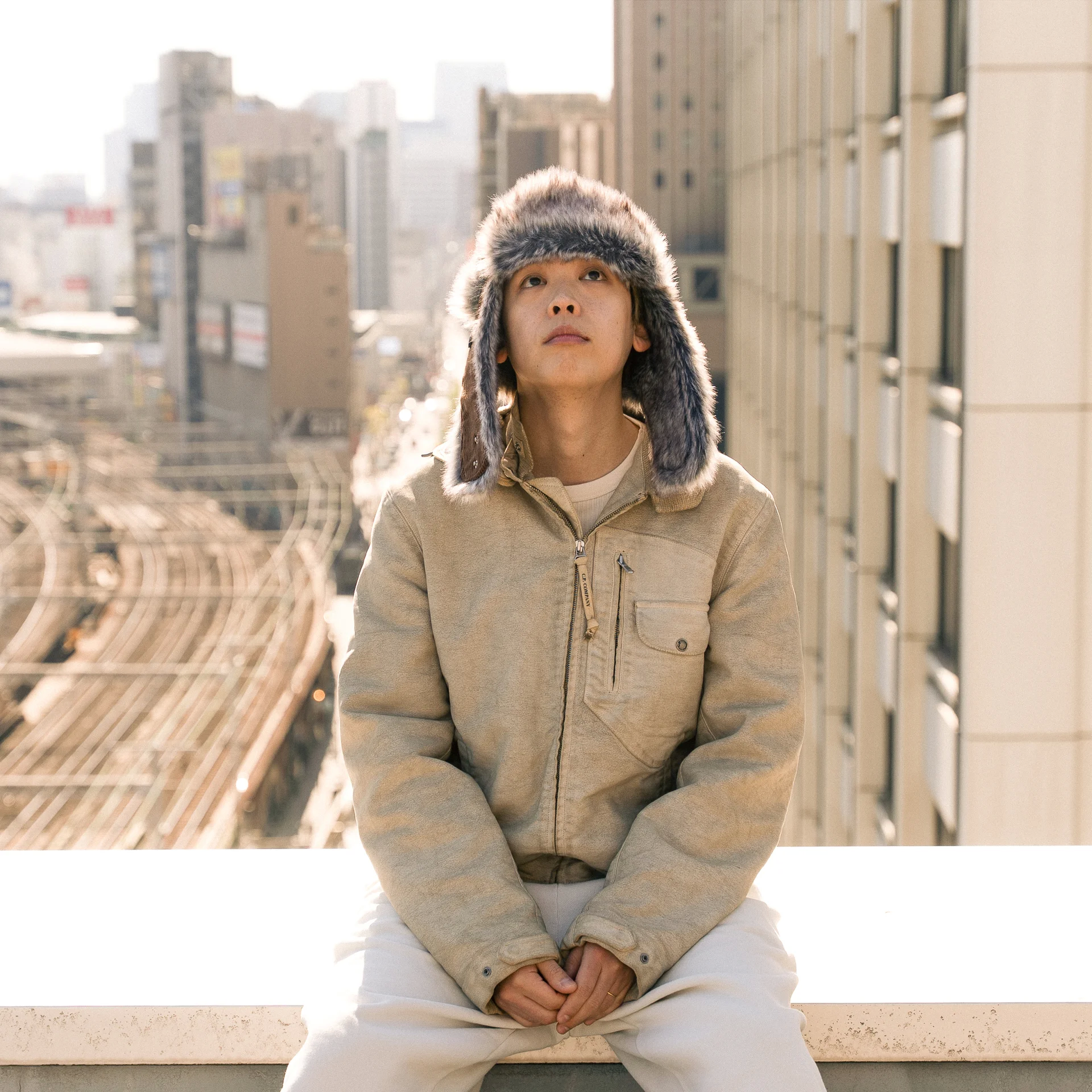 도시를 내려다보며 옥상에 앉아 있는 SALU