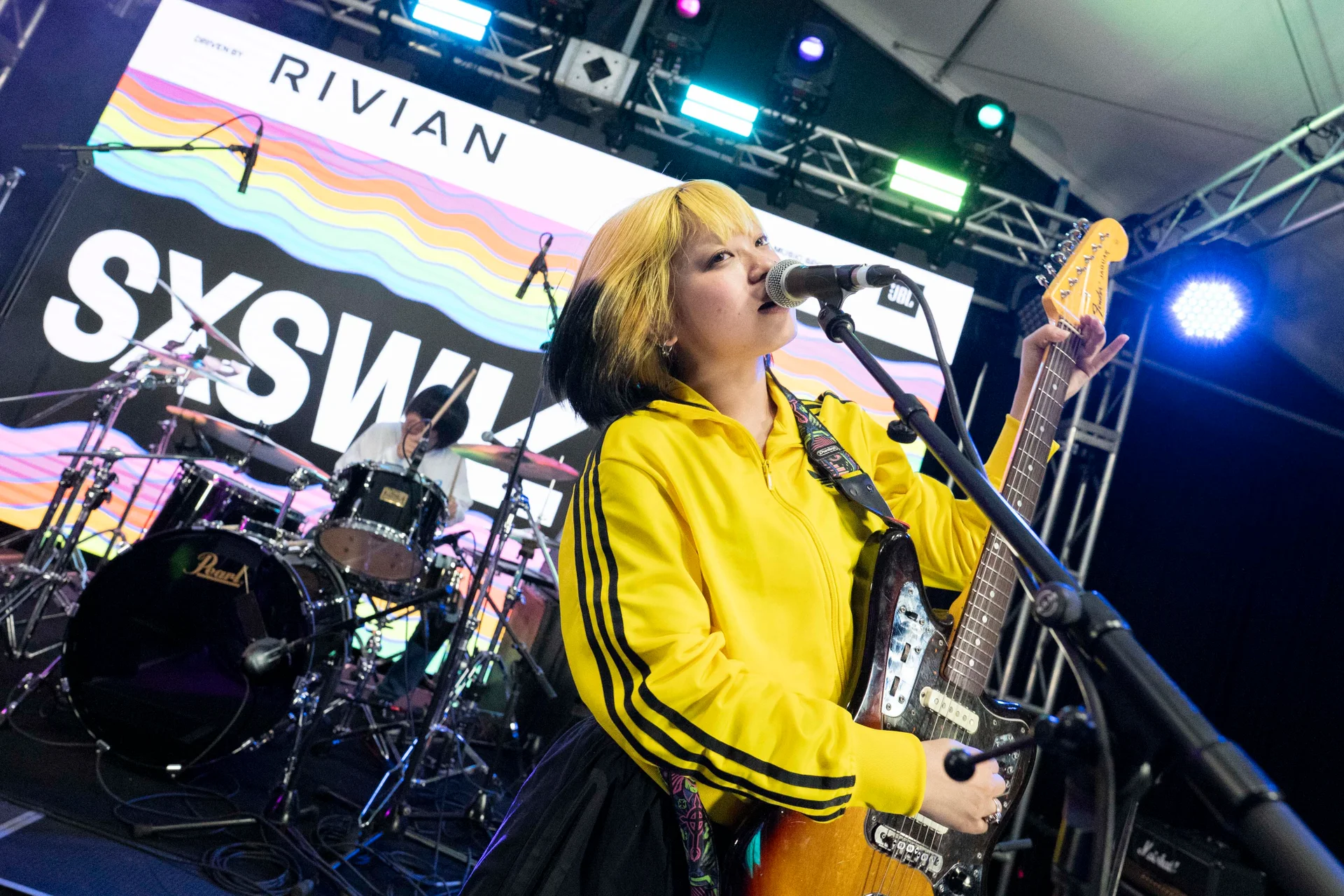 Muzyk występujący na SXSW z gitarą elektryczną i światłami sceny