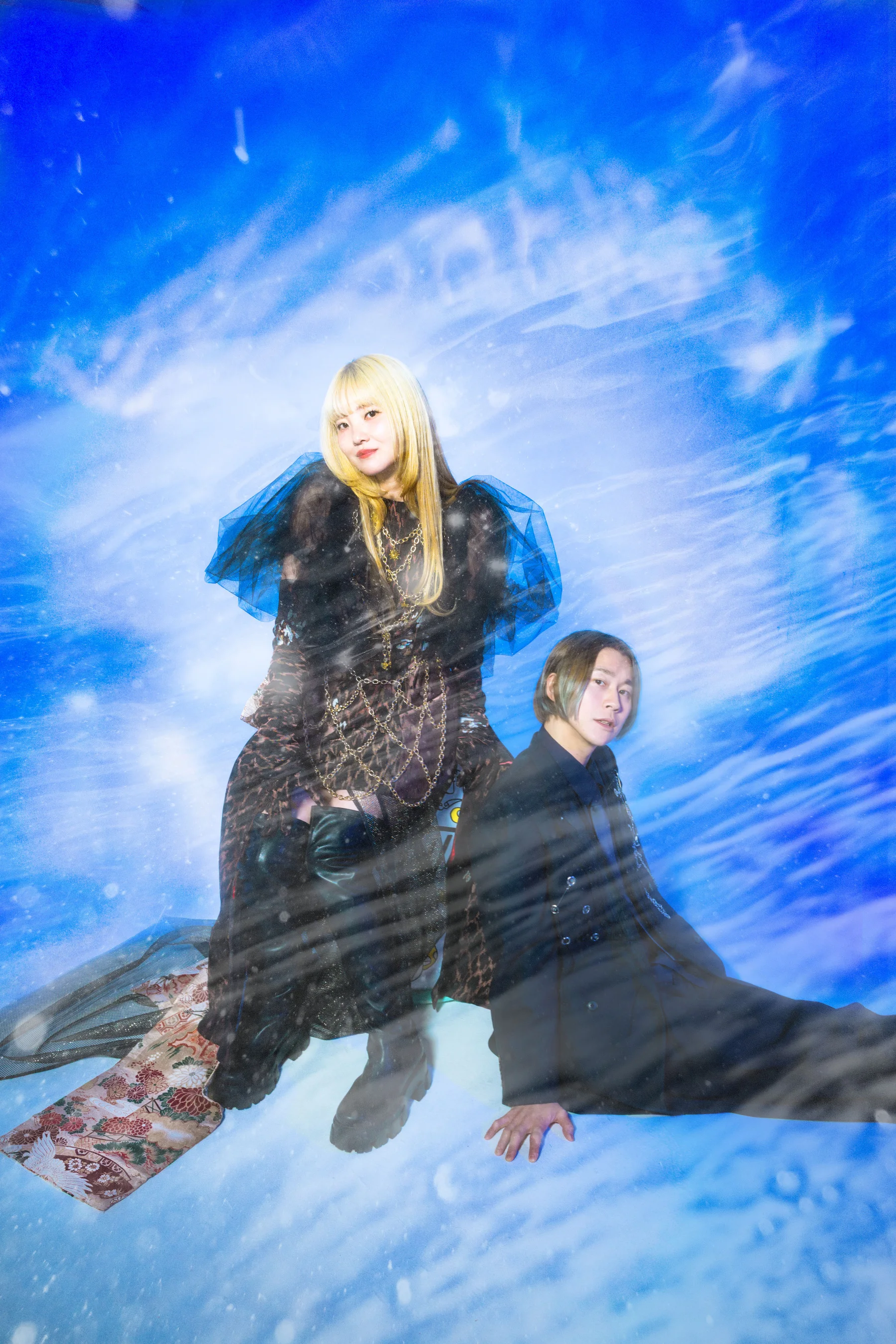 SpecialThanks band members seated against a blue backdrop