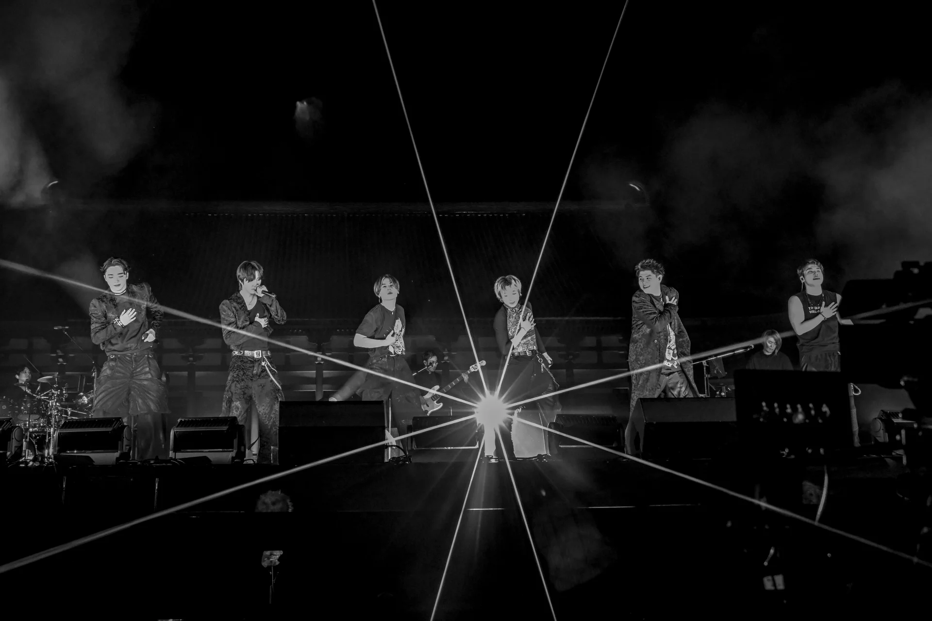 یک گروه موسیقی در حال اجرا روی صحنه با نورپردازی چشمگیر