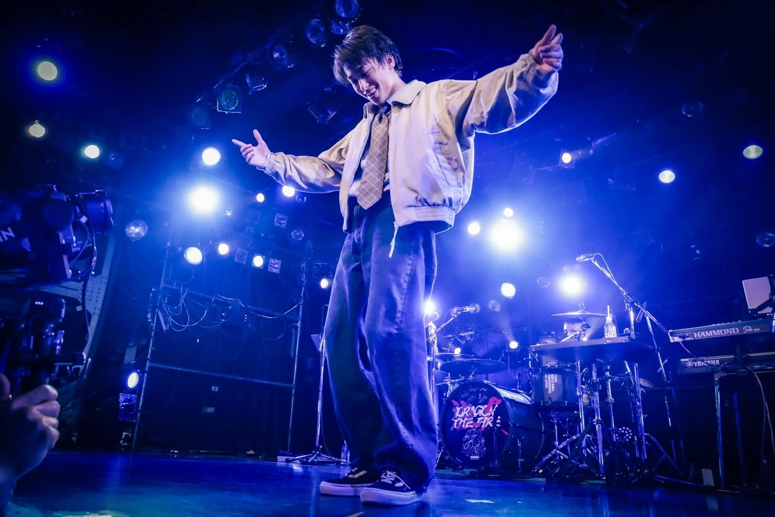 Ryu actuando en el escenario bajo luces azules