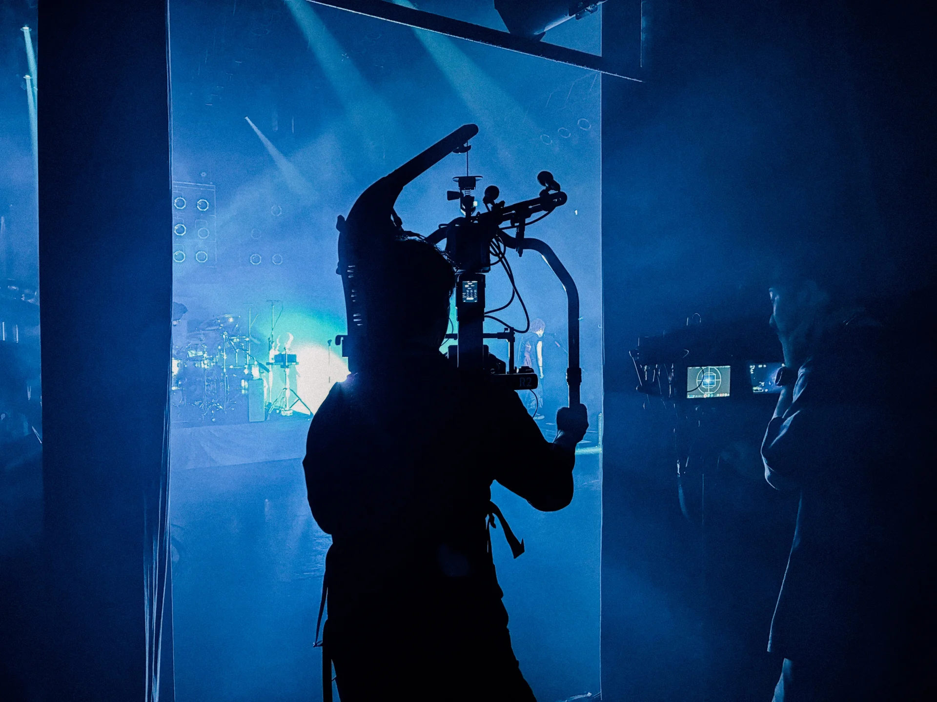 Silhouetted cameraman filming a concert
