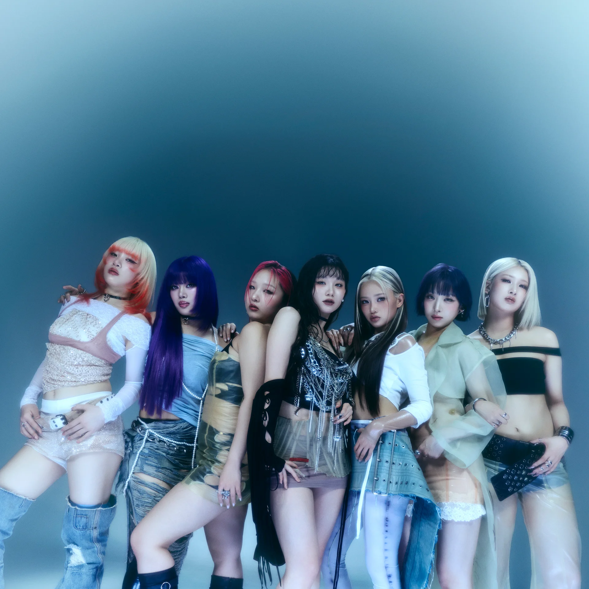 De sju medlemmarna i HANA poserar tillsammans i stilsäkra outfits mot en blå gradientbakgrund.