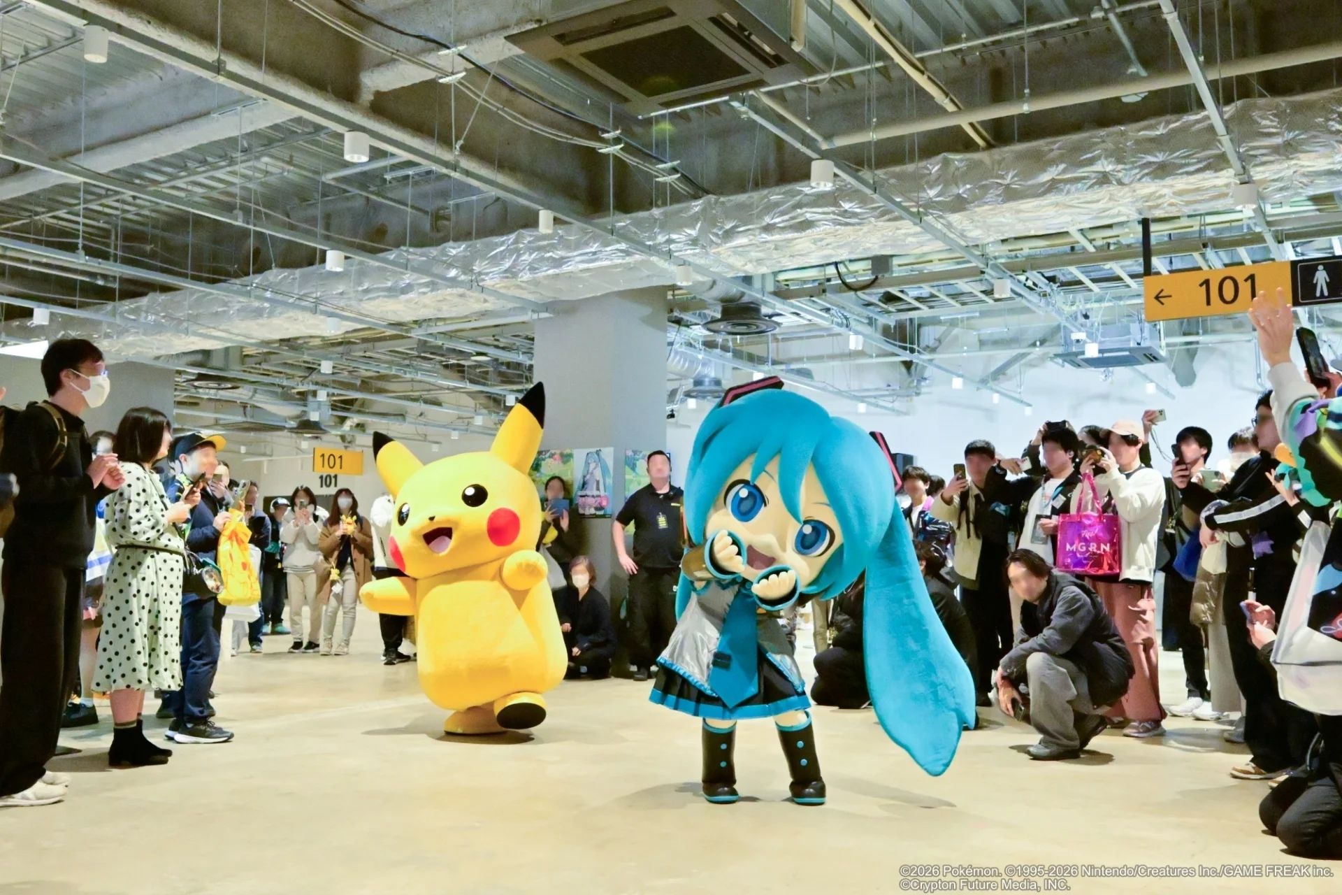 Pikachu and Hatsune Miku mascots performing together on stage