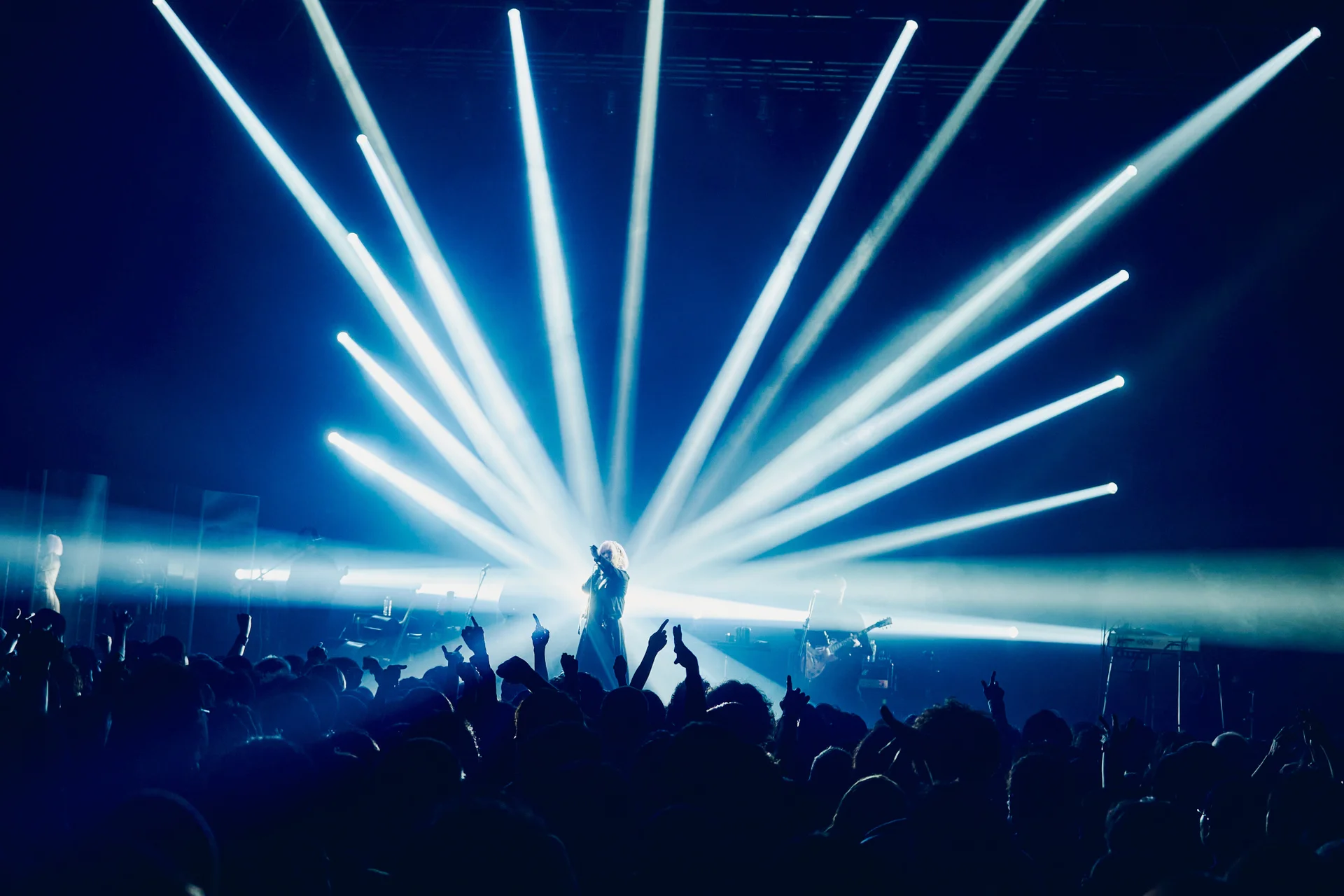 Silueta vystupujúceho na pódiu s modrým osvetlením