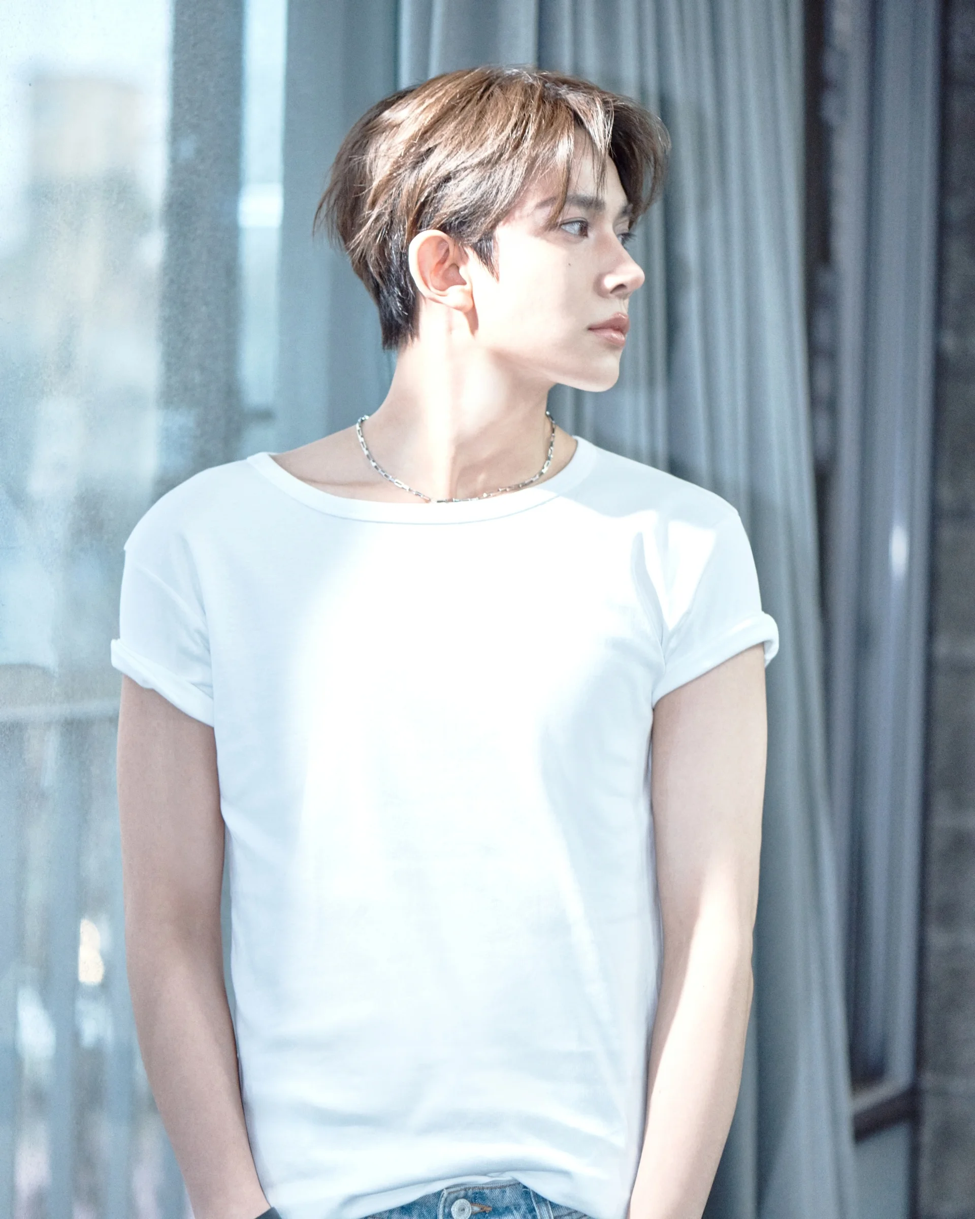 EVAN בחולצה לבנה ליד חלון