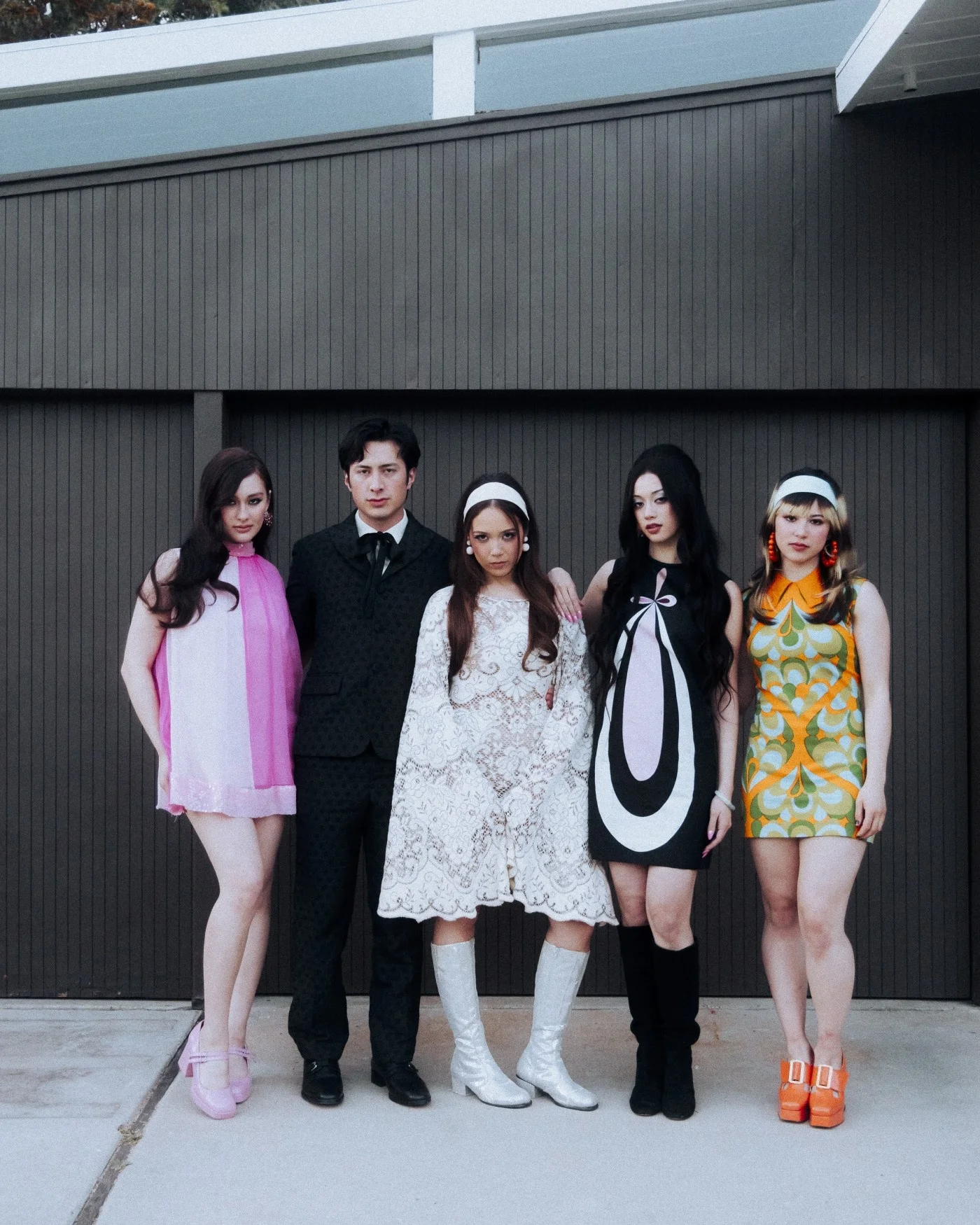 Cast of the Madwoman music video posing in retro outfits