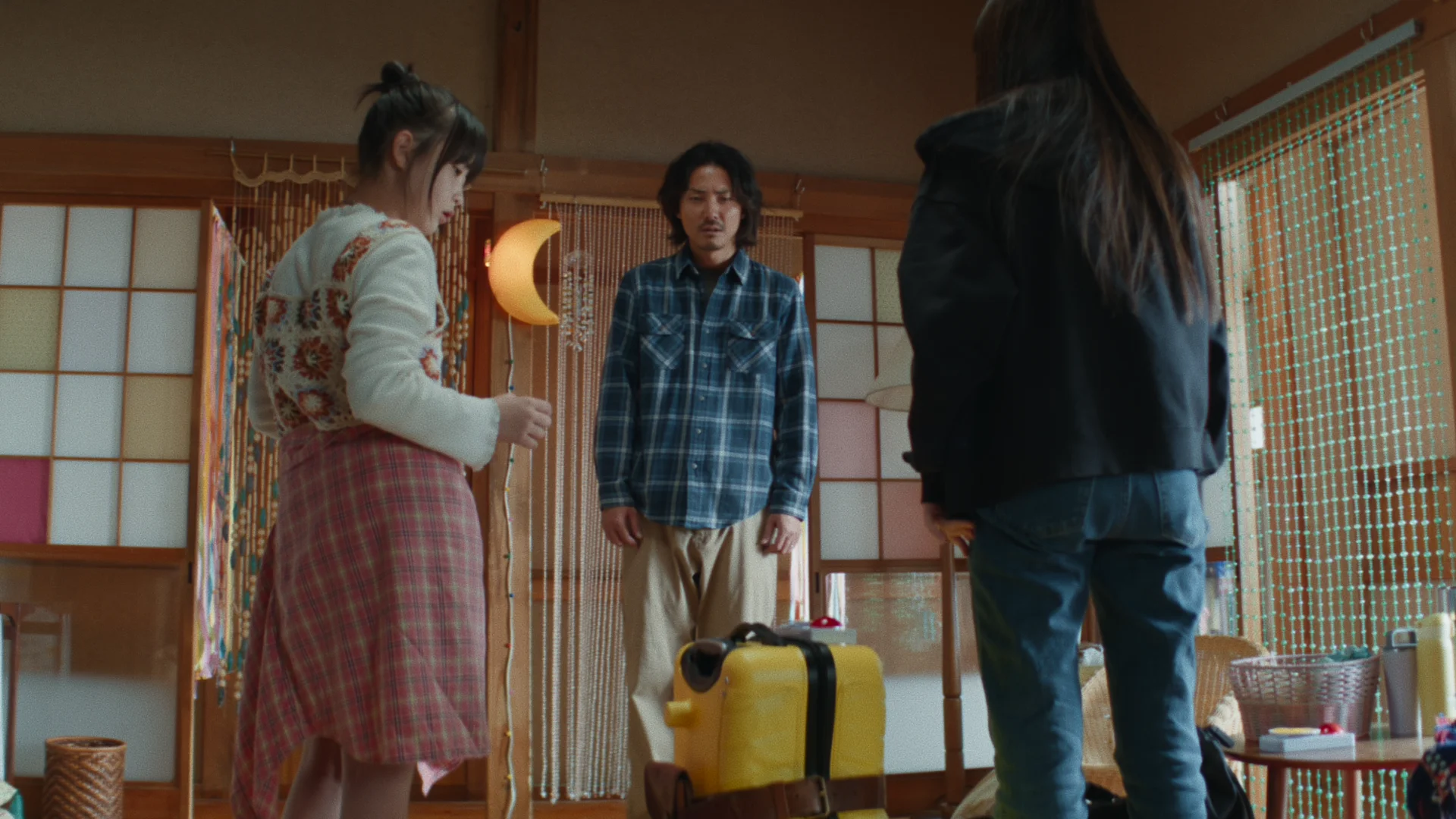 Scéna z filmu ukazující tři osoby v pokoji v japonském stylu.