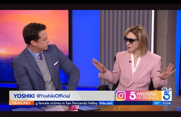 Ο YOSHIKι σε ροζ κοστούμι μιλάει με παρουσιαστή στο KTLA