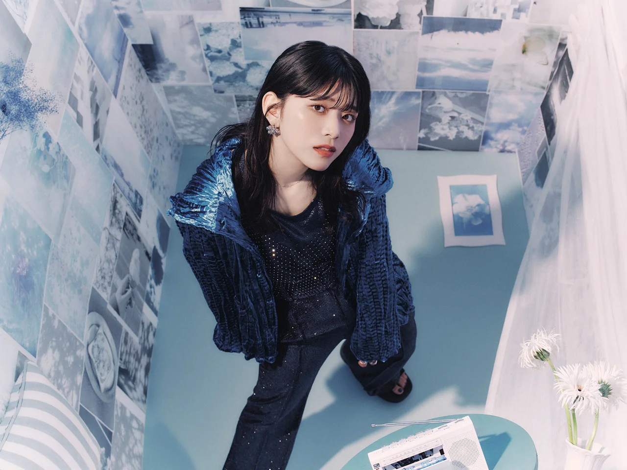 Kawanishi Natsuki sitting in a room with blue decor and photo collages
