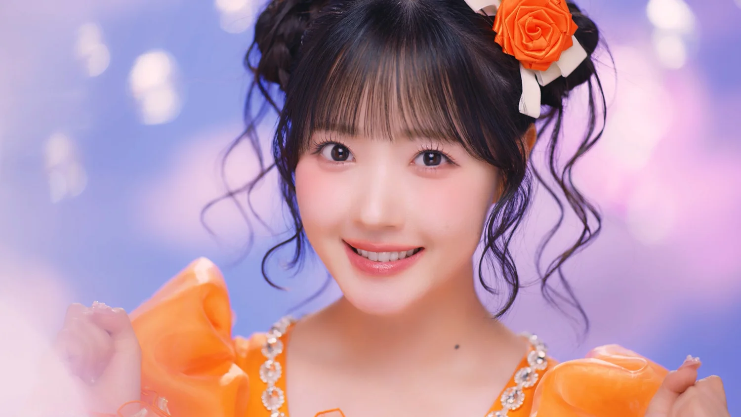Một <a href="https://onlyhit.us/music/artist/CUTIE%20STREET" target="_blank">thành viên CUTIE STREET</a> trong trang phục màu cam đang mỉm cười