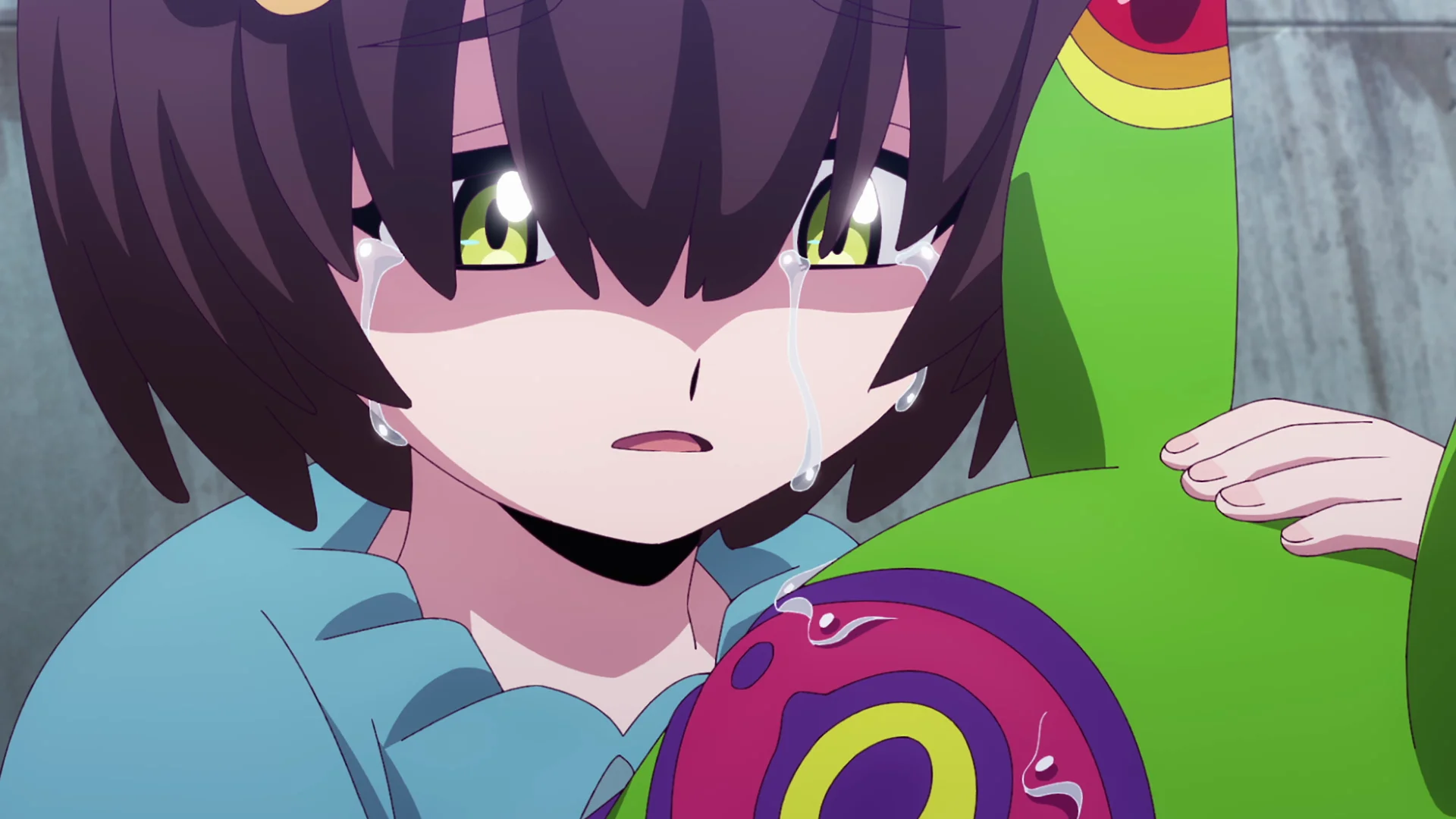 Anime character crying while holding a colorful stuffed creature