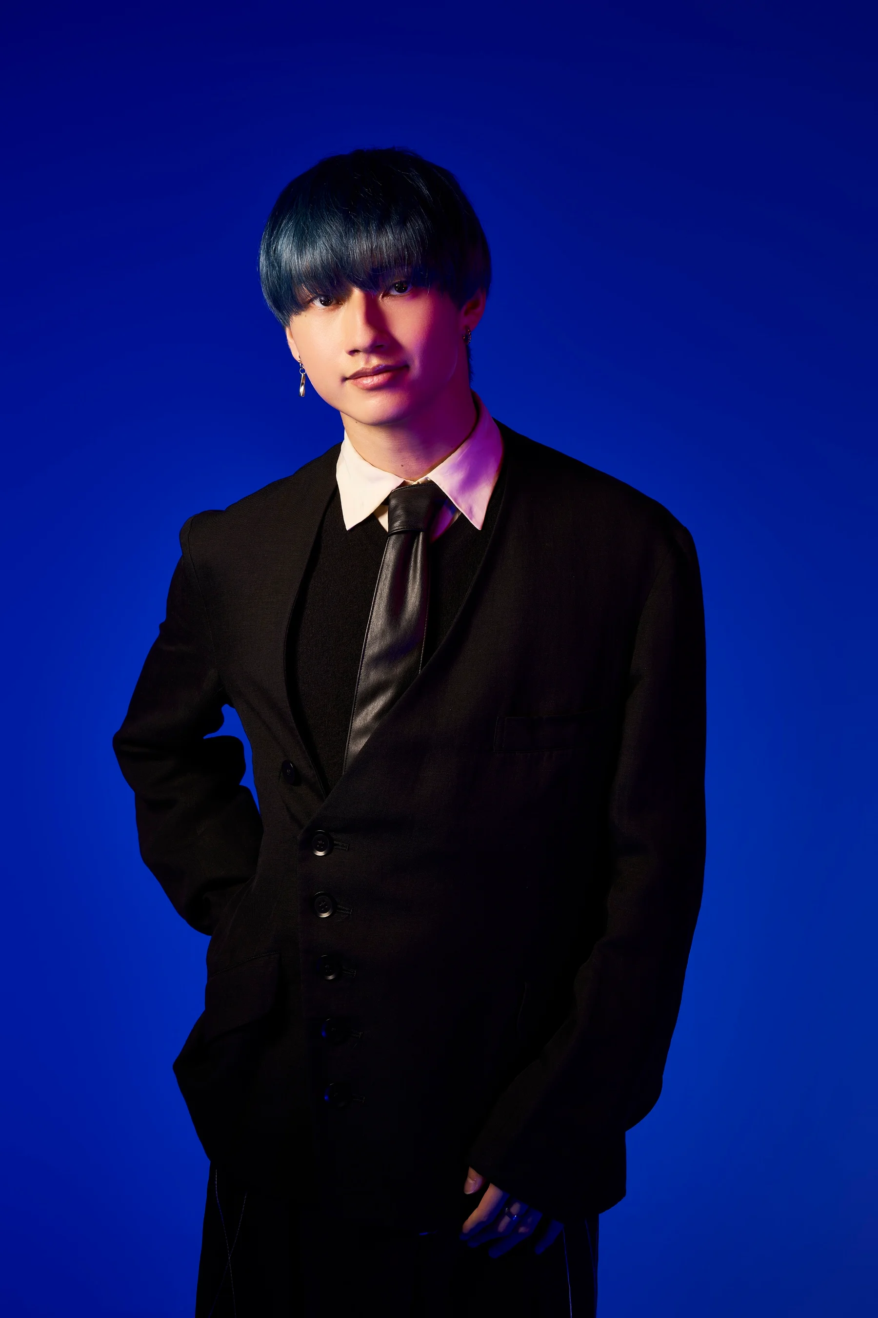 Shiryu Sejima con i capelli blu in un completo nero