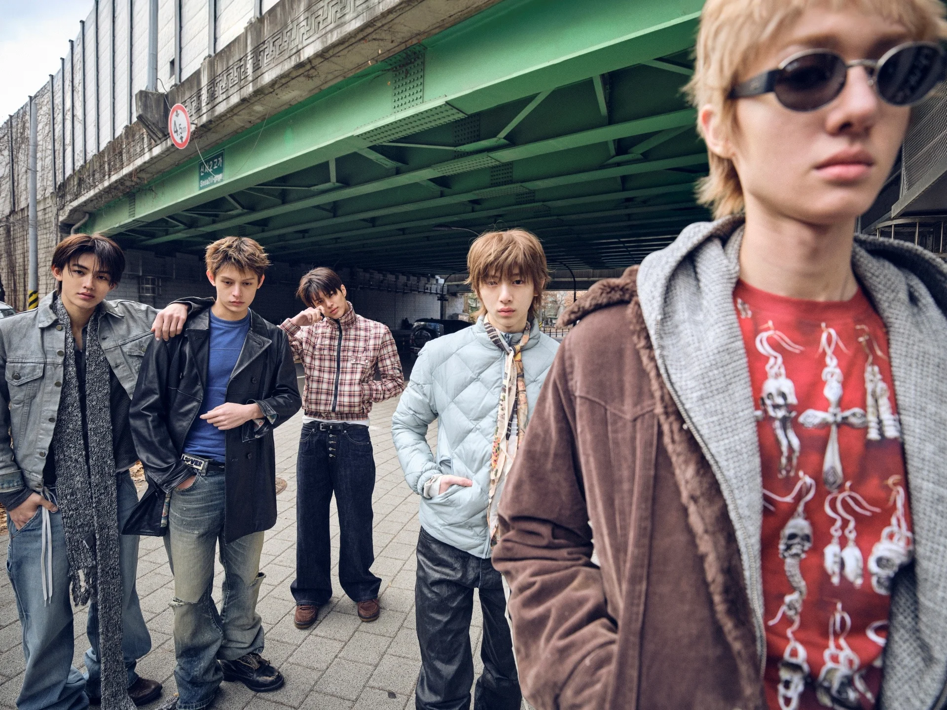 CORTIS members posing under a bridge