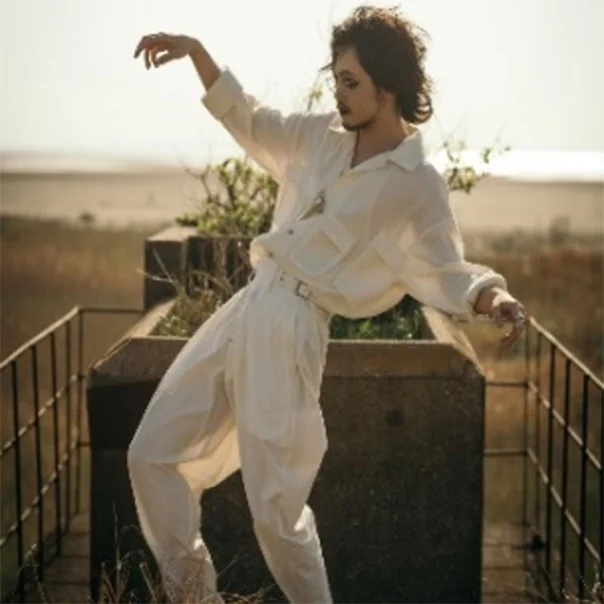 A person in white clothing posing outdoors