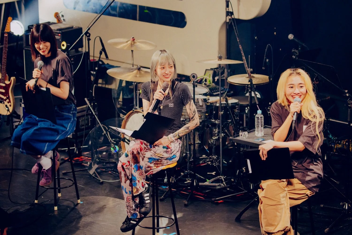 Chilli Beans. members seated on stage with instruments