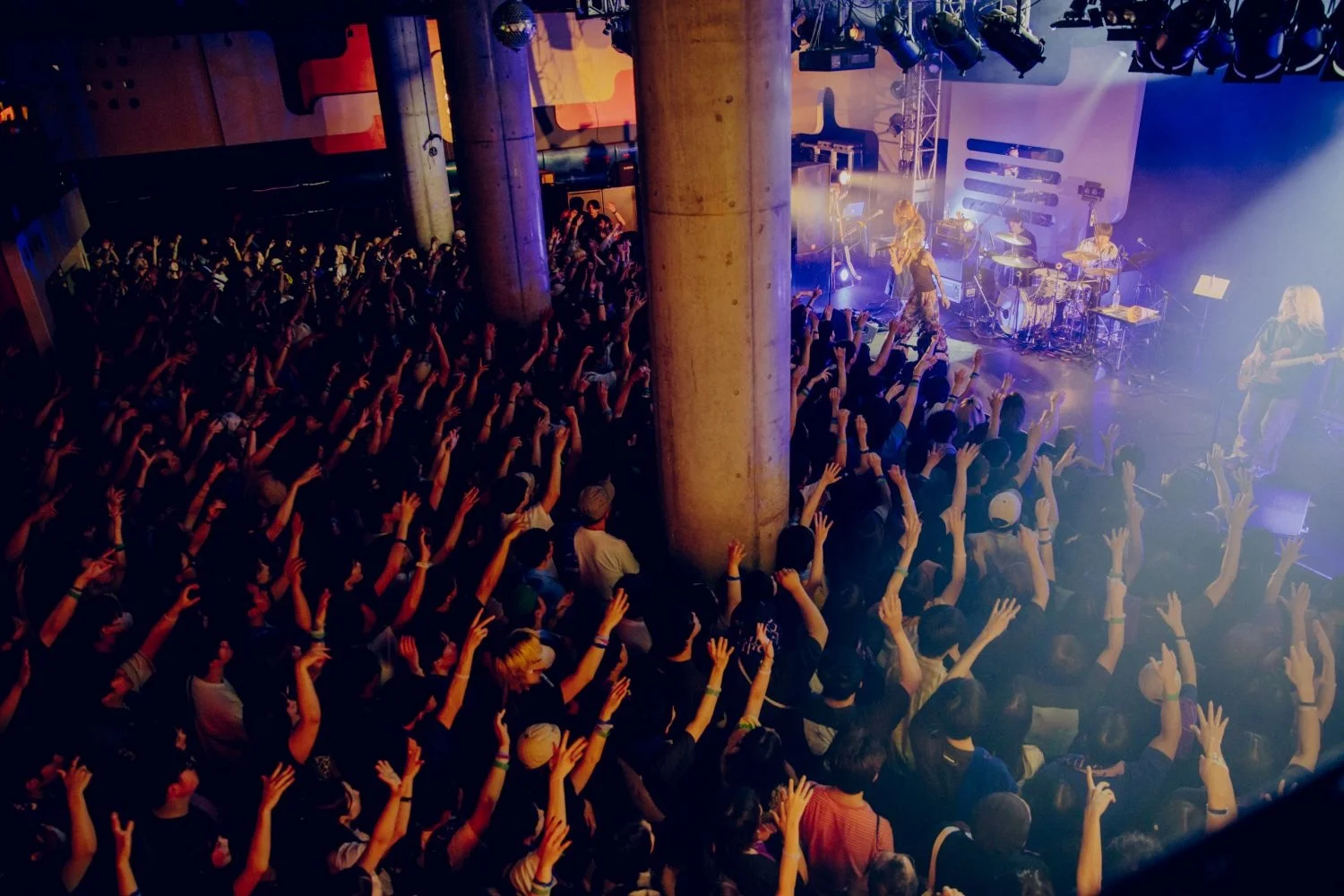 Crowd at a <a href="https://onlyhit.us/music/artist/Chilli%20Beans." target="_blank">Chilli Beans.</a> concert under colorful lights