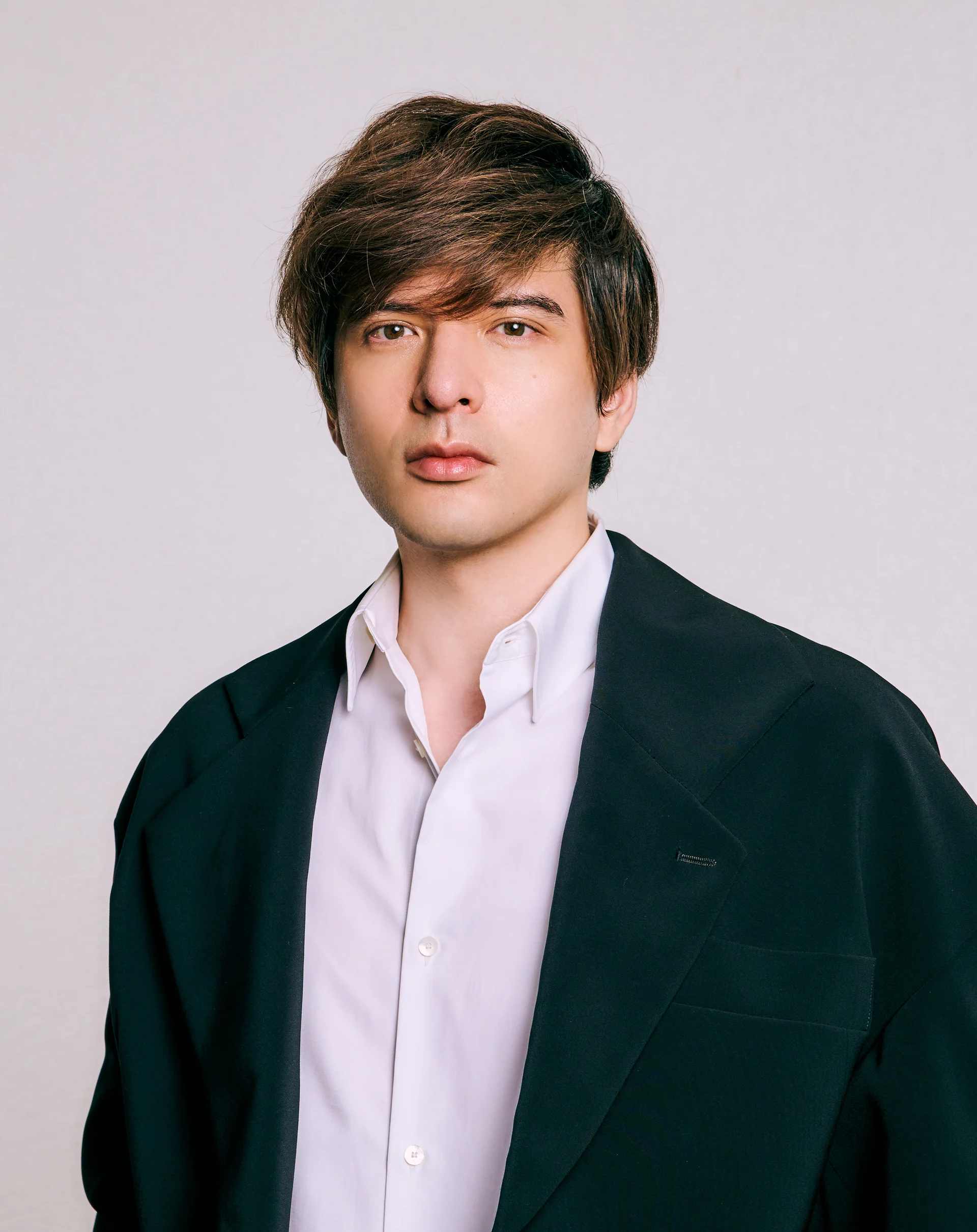 Näyttelijä Yu Shirota valkoisessa paidassa ja tummassa takissa