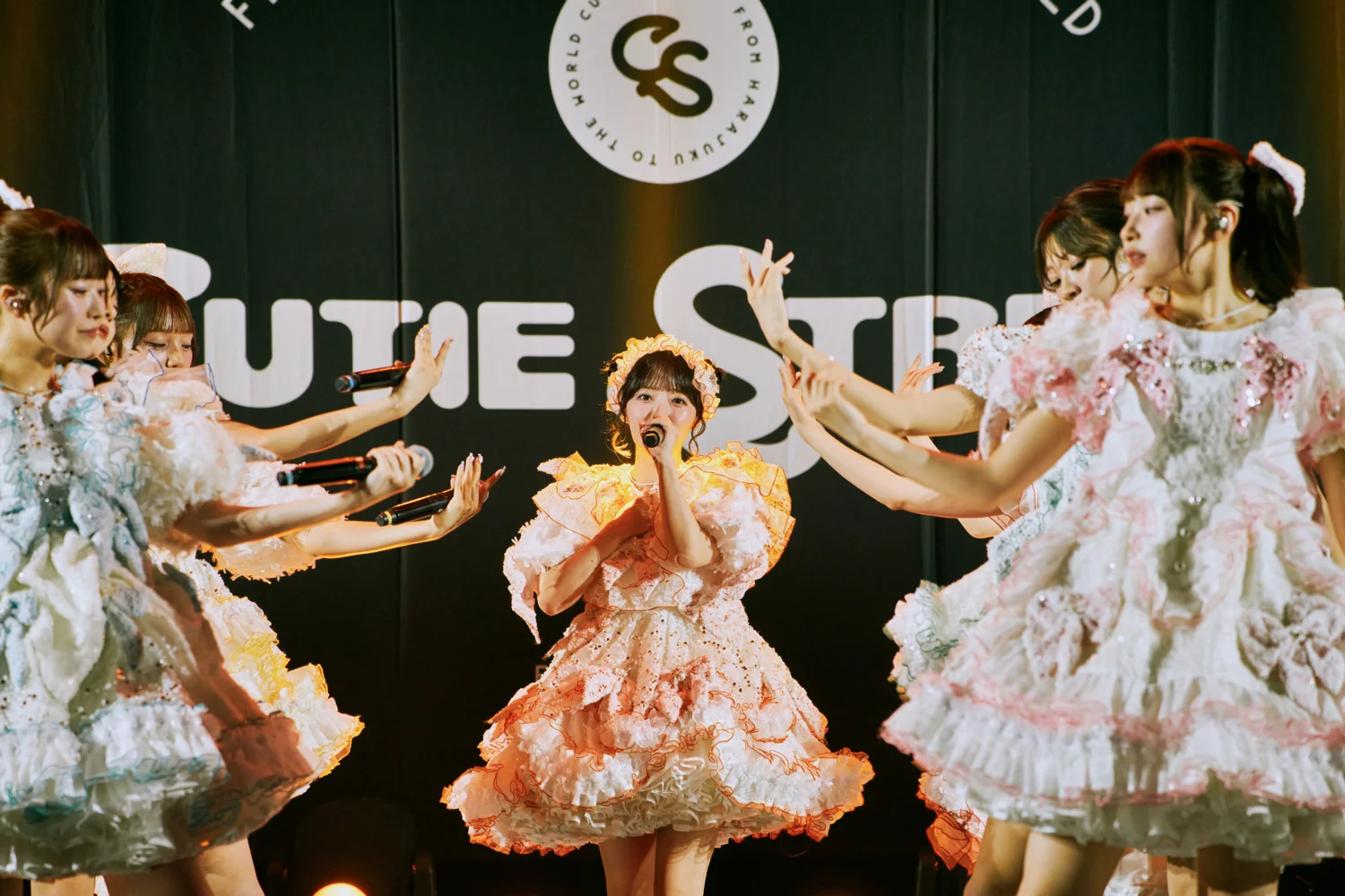 CUTIE STREET group shot on stage with logo in background