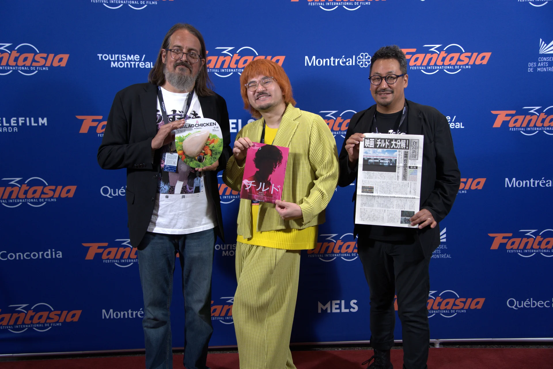 Réalisateurs au festival Fantasia tenant la plaque du prix et une affiche