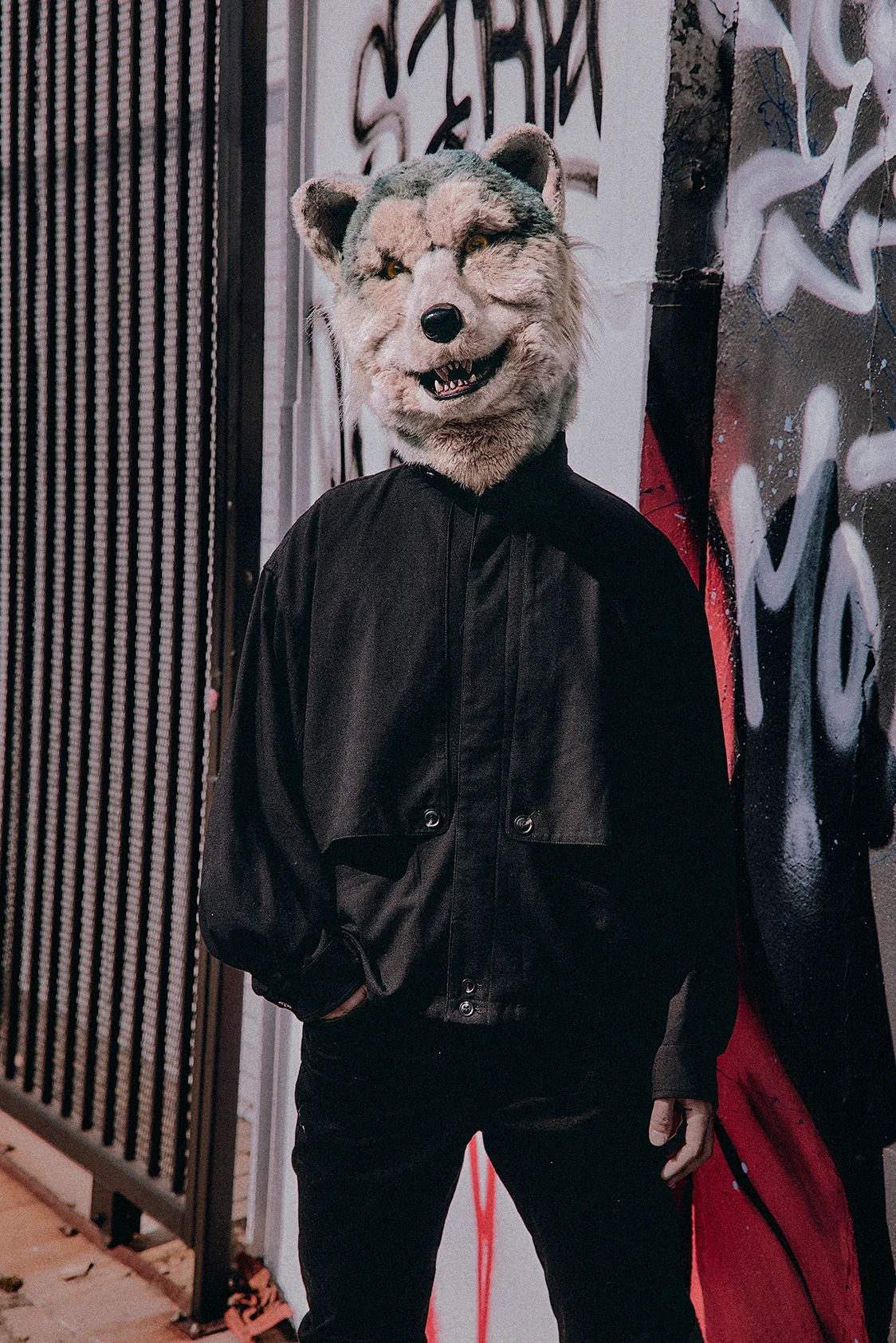 Membru MAN WITH A MISSION în mască de lup pe fundal cu graffiti