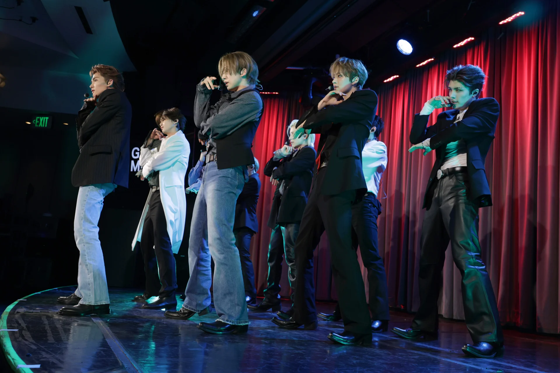 &TEAM performing on stage with red curtains