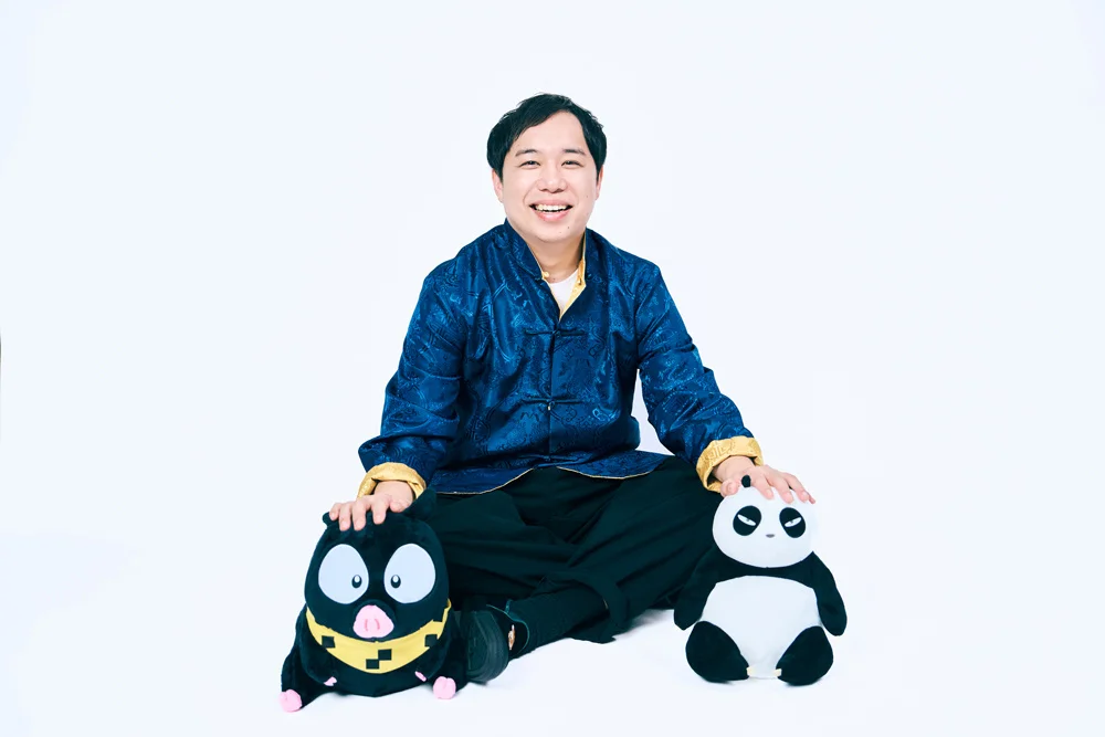Comedian Seiya smiling with panda and pig plush toys