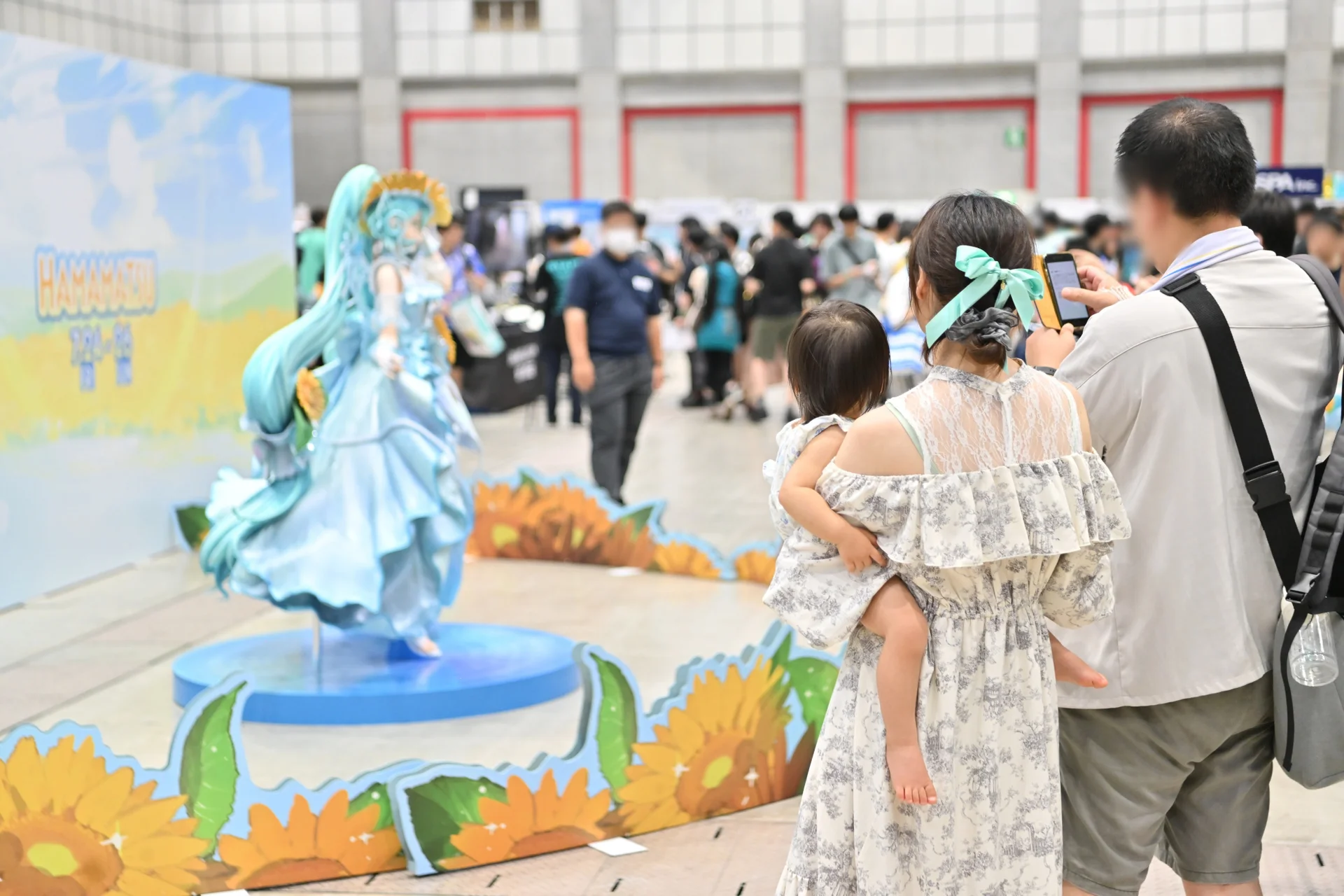 Θεατές που φωτογραφίζουν ένα άγαλμα της Hatsune Miku στην έκθεση