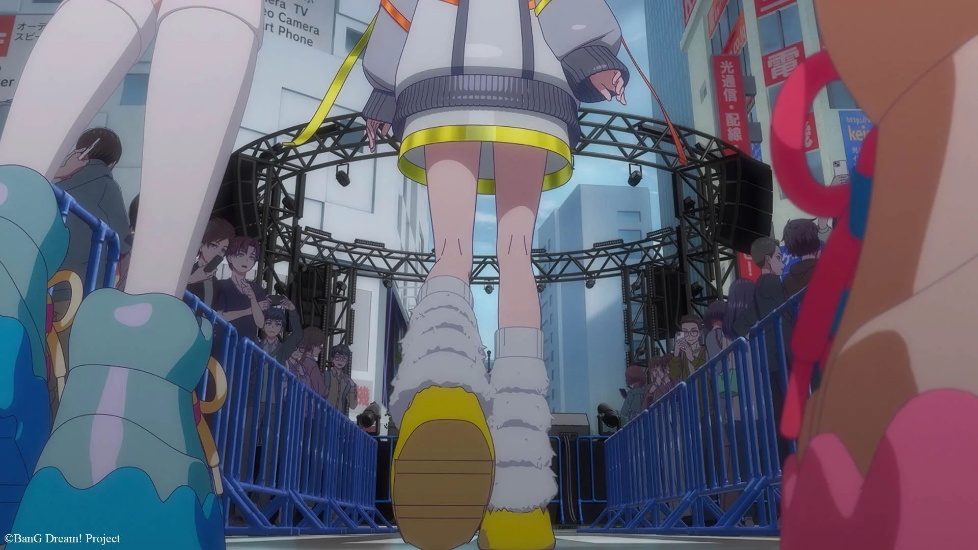 Anime veikėjai vaikšto link scenos miesto aplinkoje