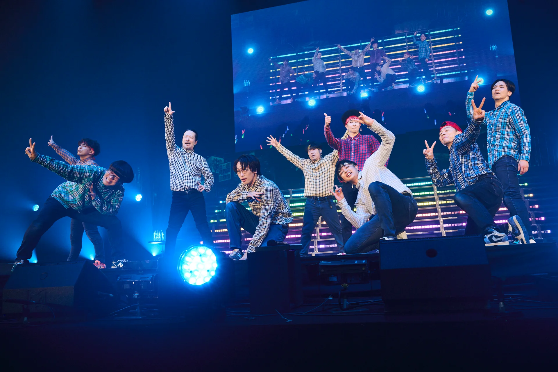 REAL AKIBA BOYZ performing on stage with colorful lighting