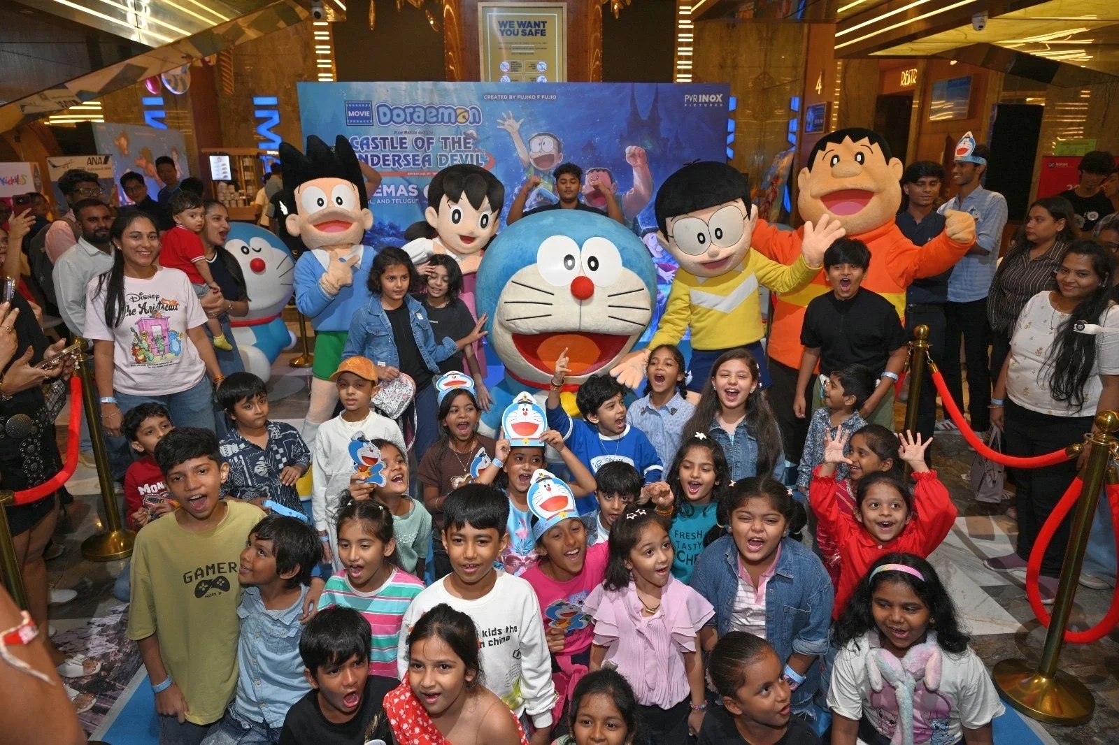 Nens amb siluetes de cartró dels personatges de Doraemon en un esdeveniment cinematogràfic