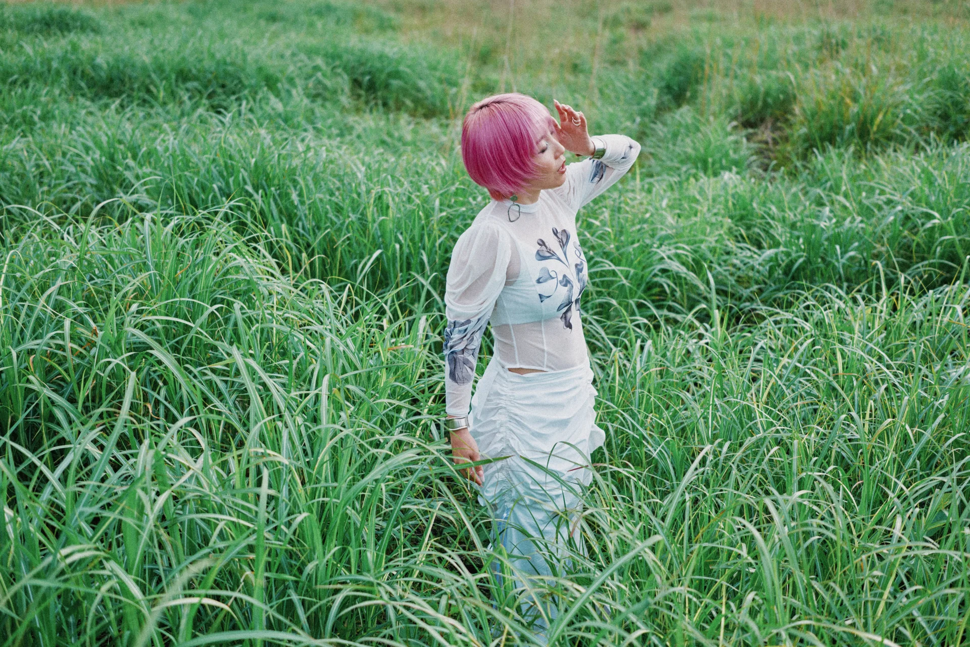 Nao Yoshioka mirant cap amunt en un camp d’herba