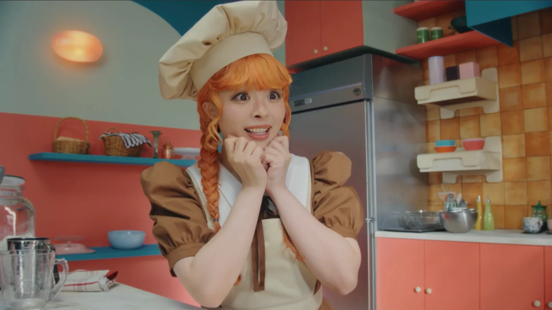 Kyary Pamyu Pamyu in a chef outfit with orange hair, hands clasped