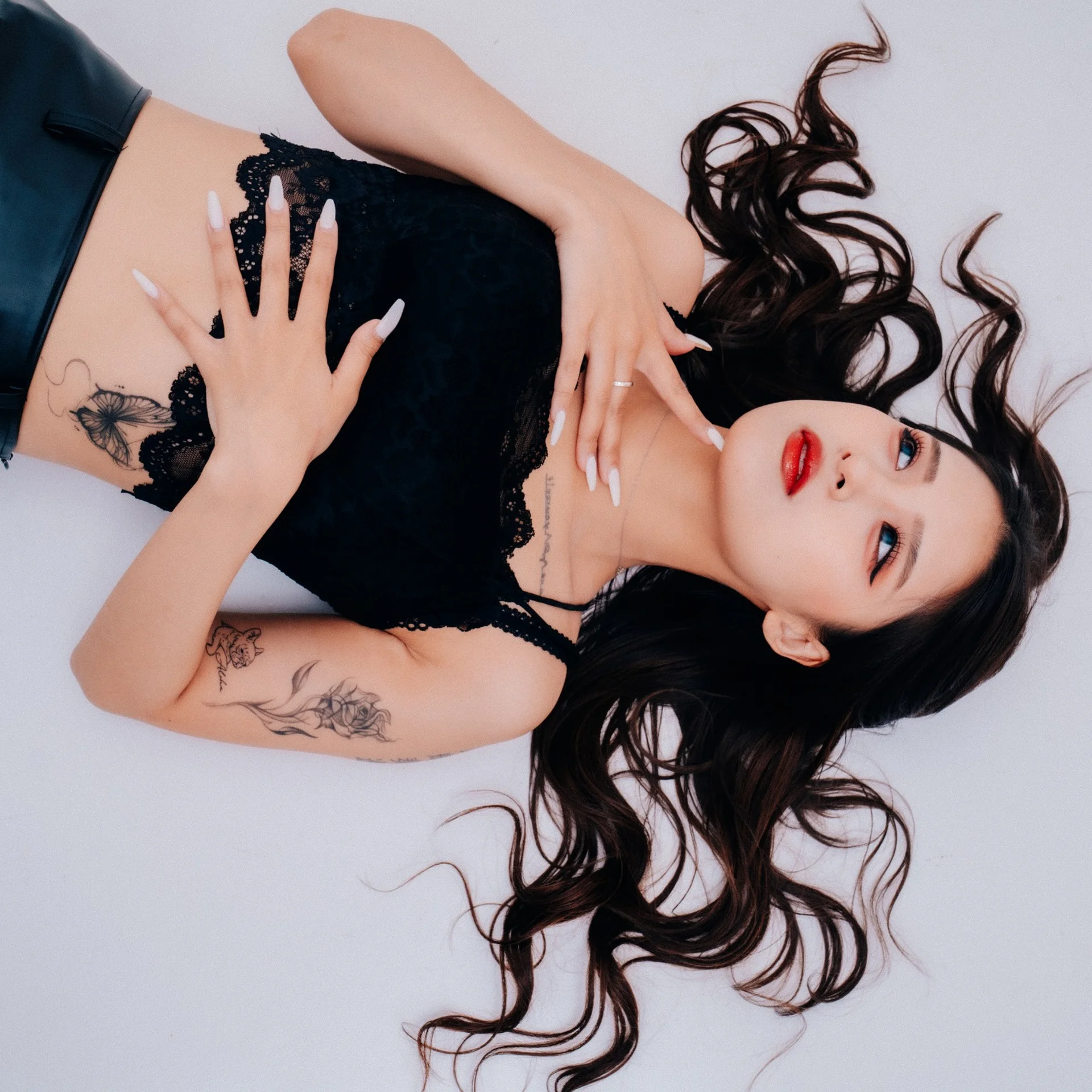 ALBA lying down, wearing a black lace top