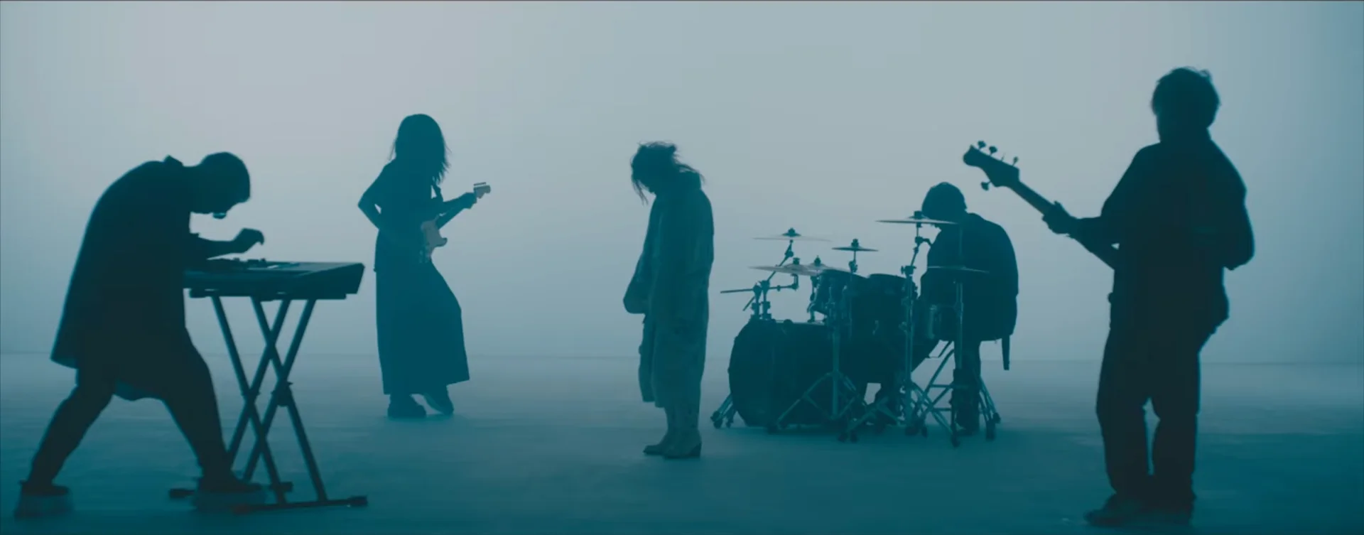 Silhouettierte Band, die in einem nebligen Setting performt.